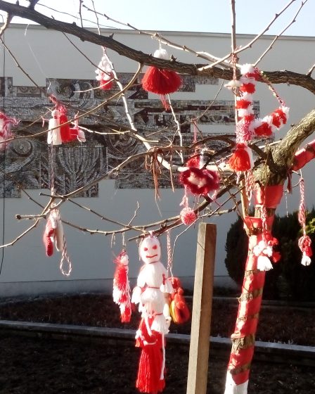 Red-and-white martenitsas hanging on a tree for Baba Marta Day