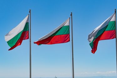 Three flags flying on a sunny day