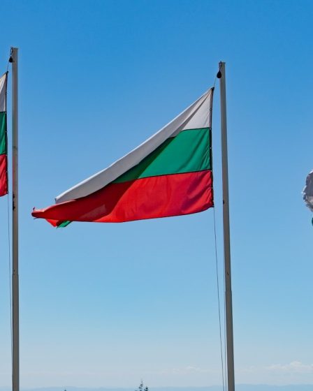 Three flags flying on a sunny day