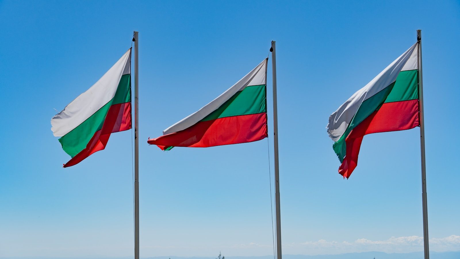 Three flags flying on a sunny day