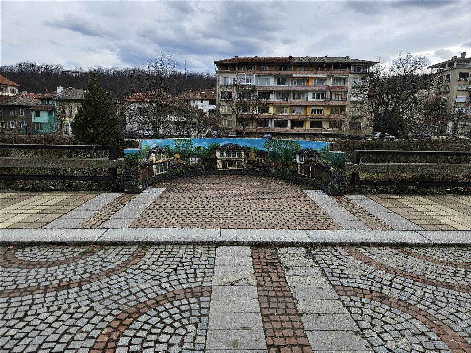 Traditional Bulgarian house mural and cobblestone square in Troyan