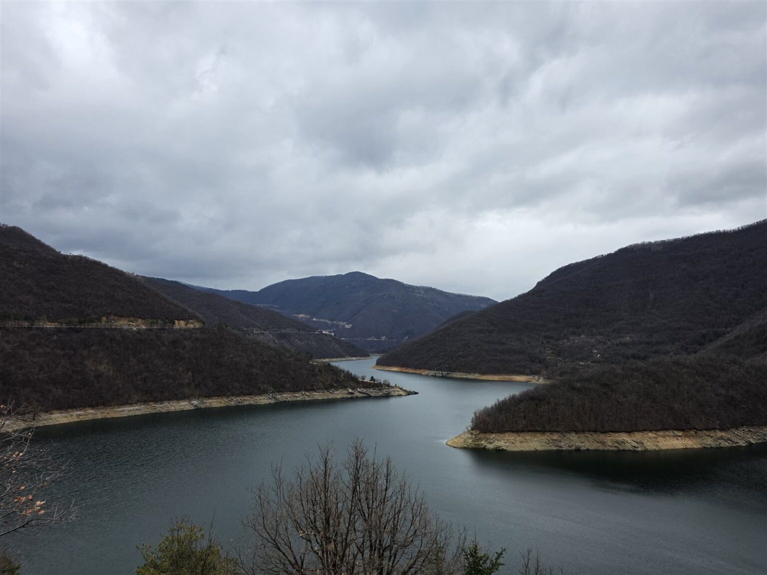 Vacha Reservoir and wooded hills in late winter