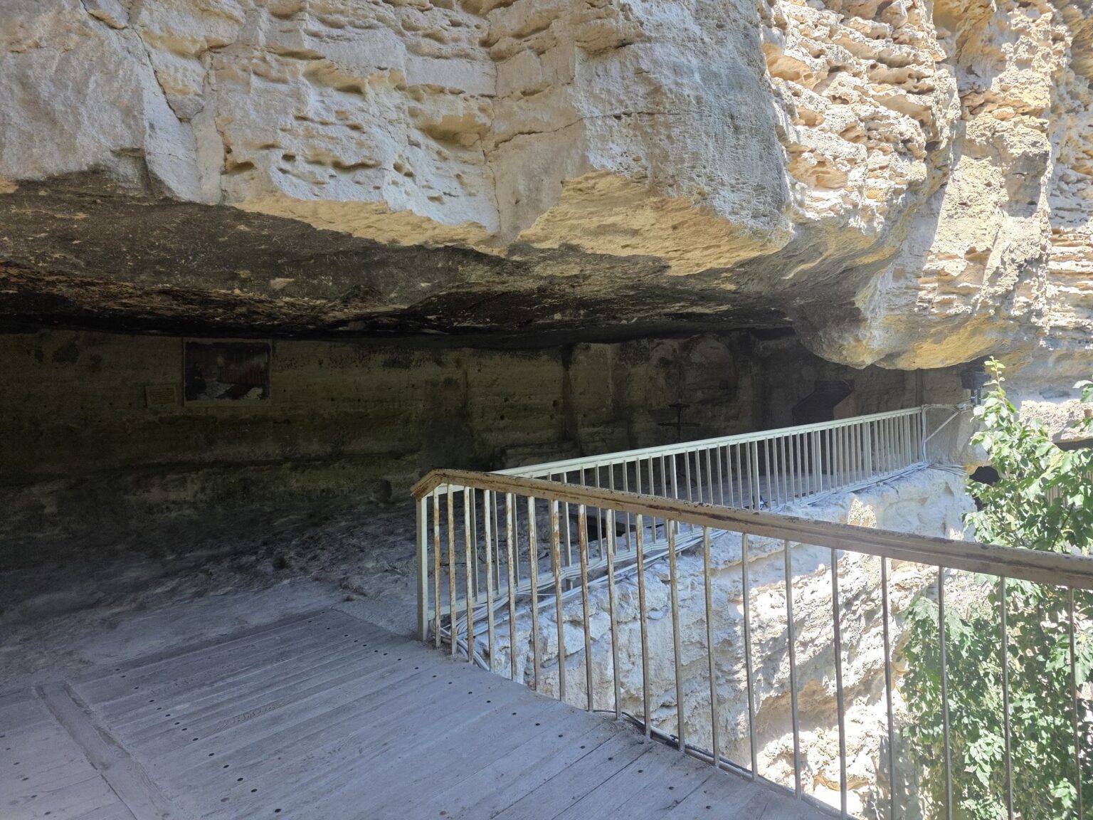 Wooden path along a rock monastery with a handrail