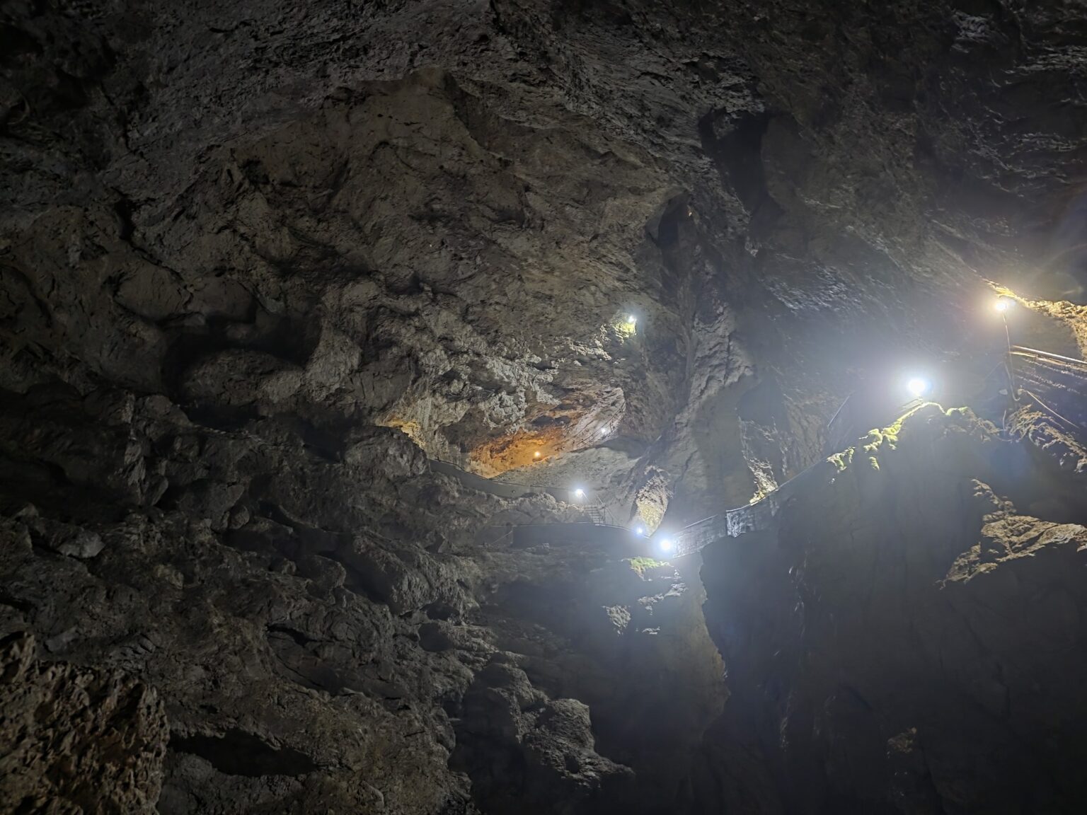 Illuminated cave path among dark rocks in dyavolskoto garlo