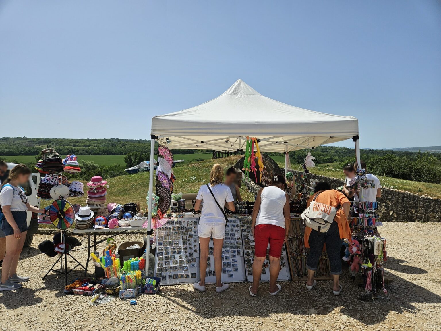 Tent with souvenirs and tourists outdoors