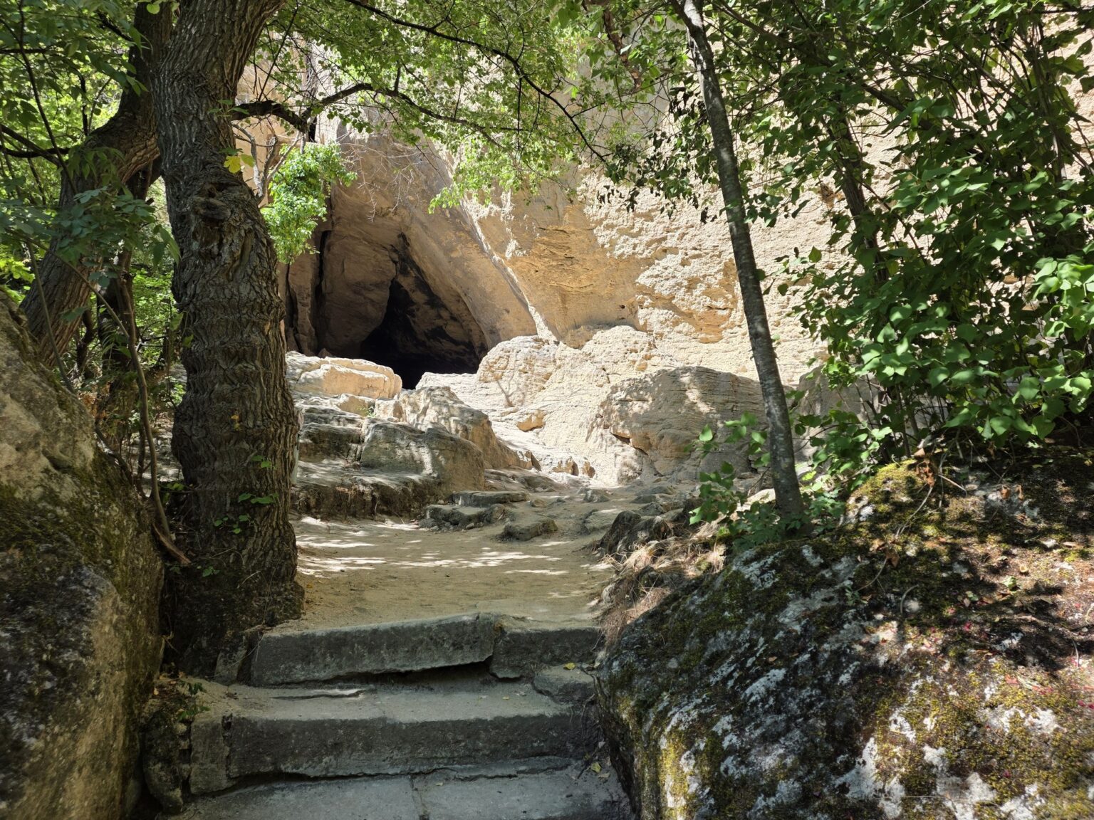 Stone stairs lead to a cave in the rocks of the Madara Rider