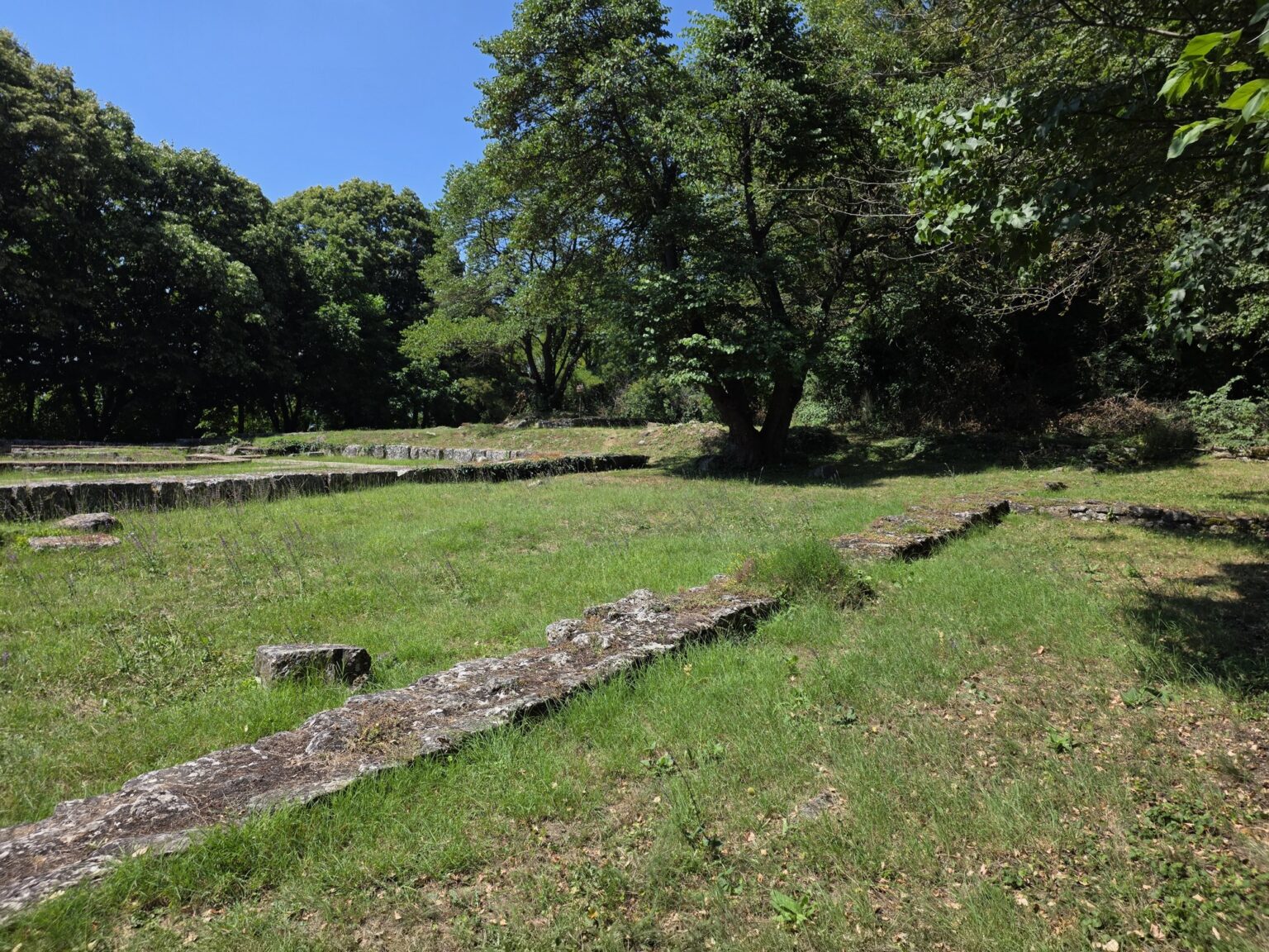 Ancient building foundations in the green meadow in Madara Rider