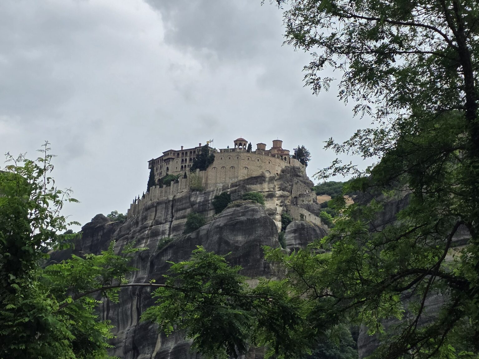 Large monastery on top of a high rock among trees