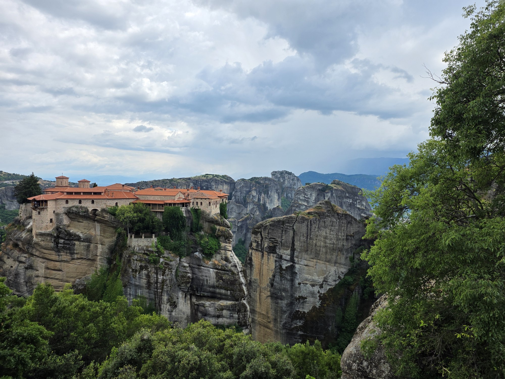 Monastery buildings with red roofs on a tall rock pillar
