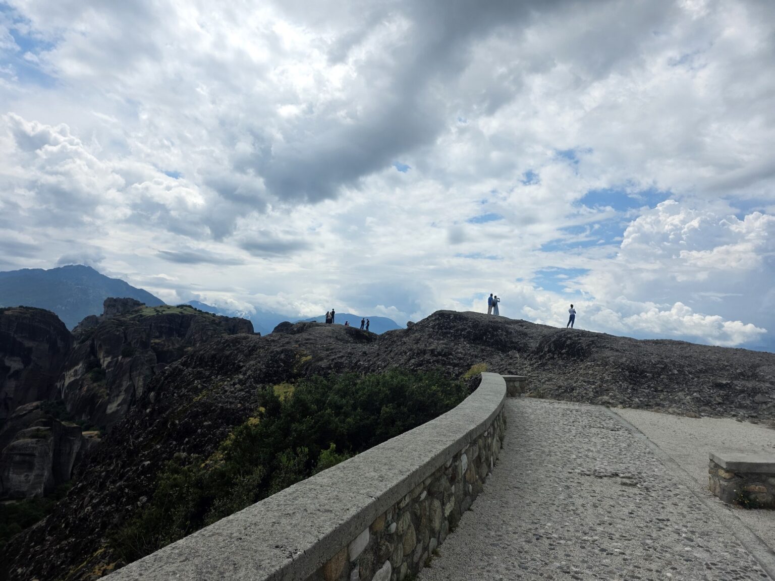Stone path with a railing and people on the rocks