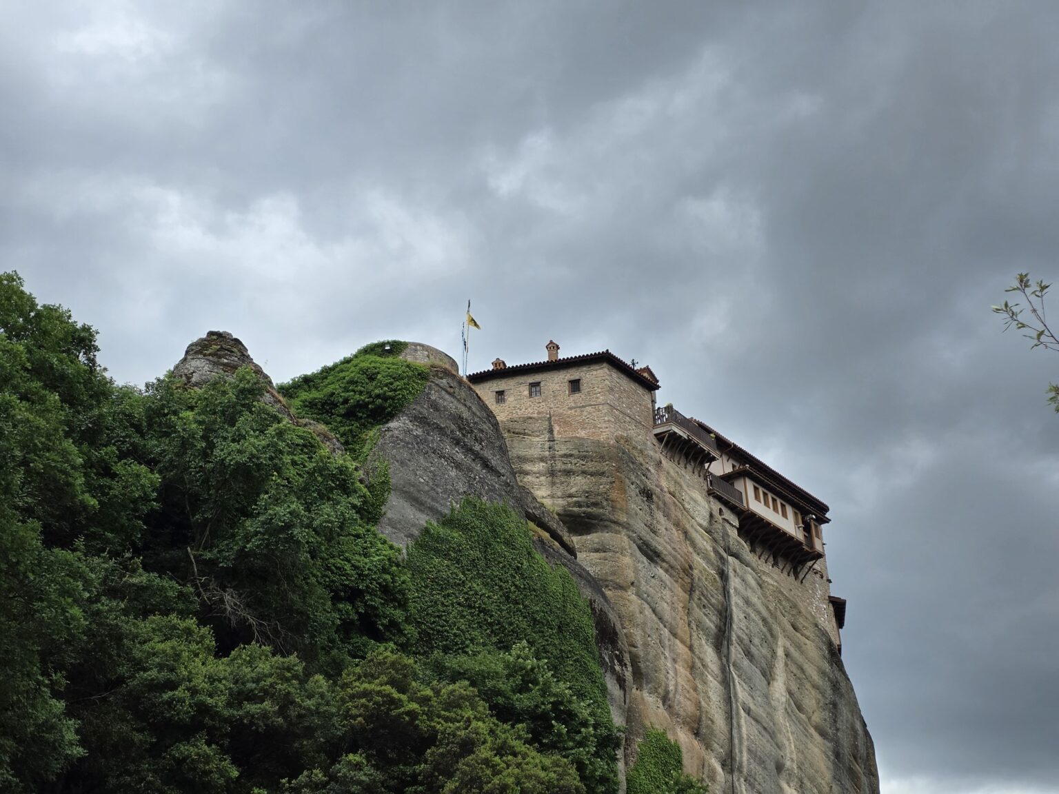 monastery on a high rock formation amidst lush greenery