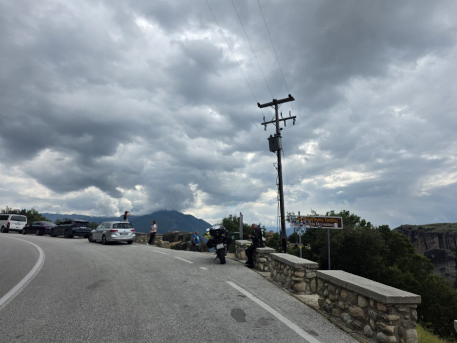 Asphalt road with parked cars and a utility pole