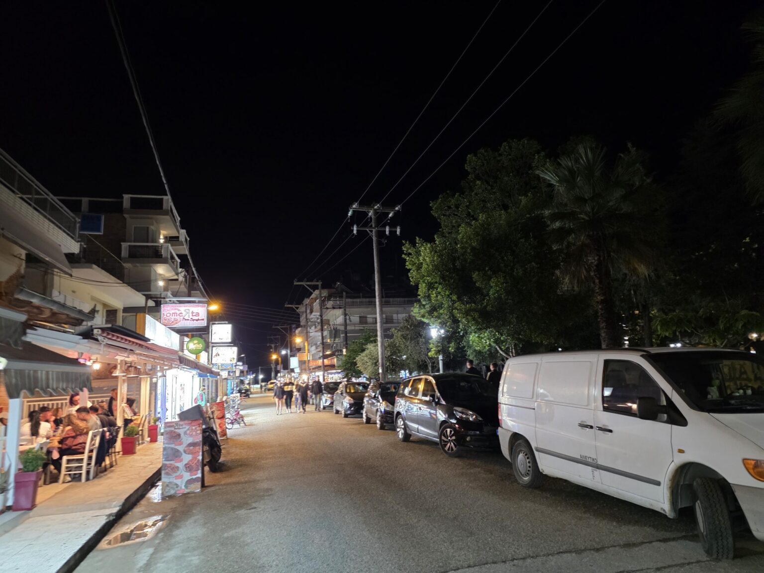 Night street with parked cars and shops