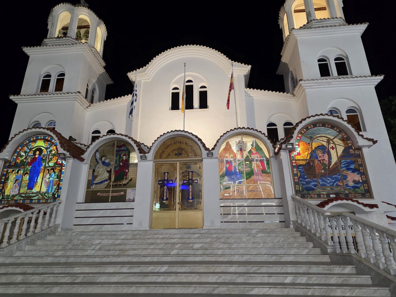 Illuminated facade of a white church with mosaics