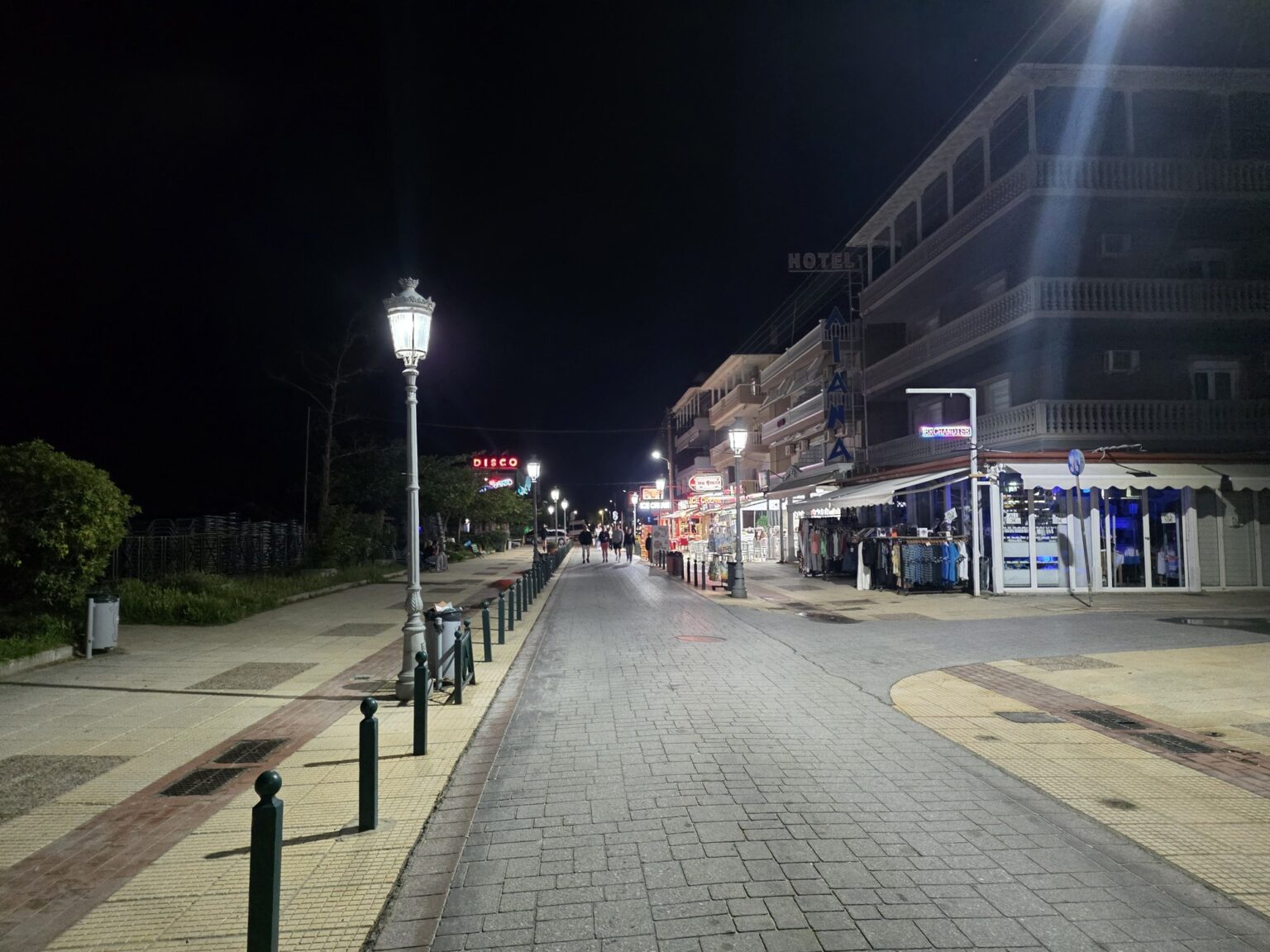 Paved alley with lamps and buildings at night