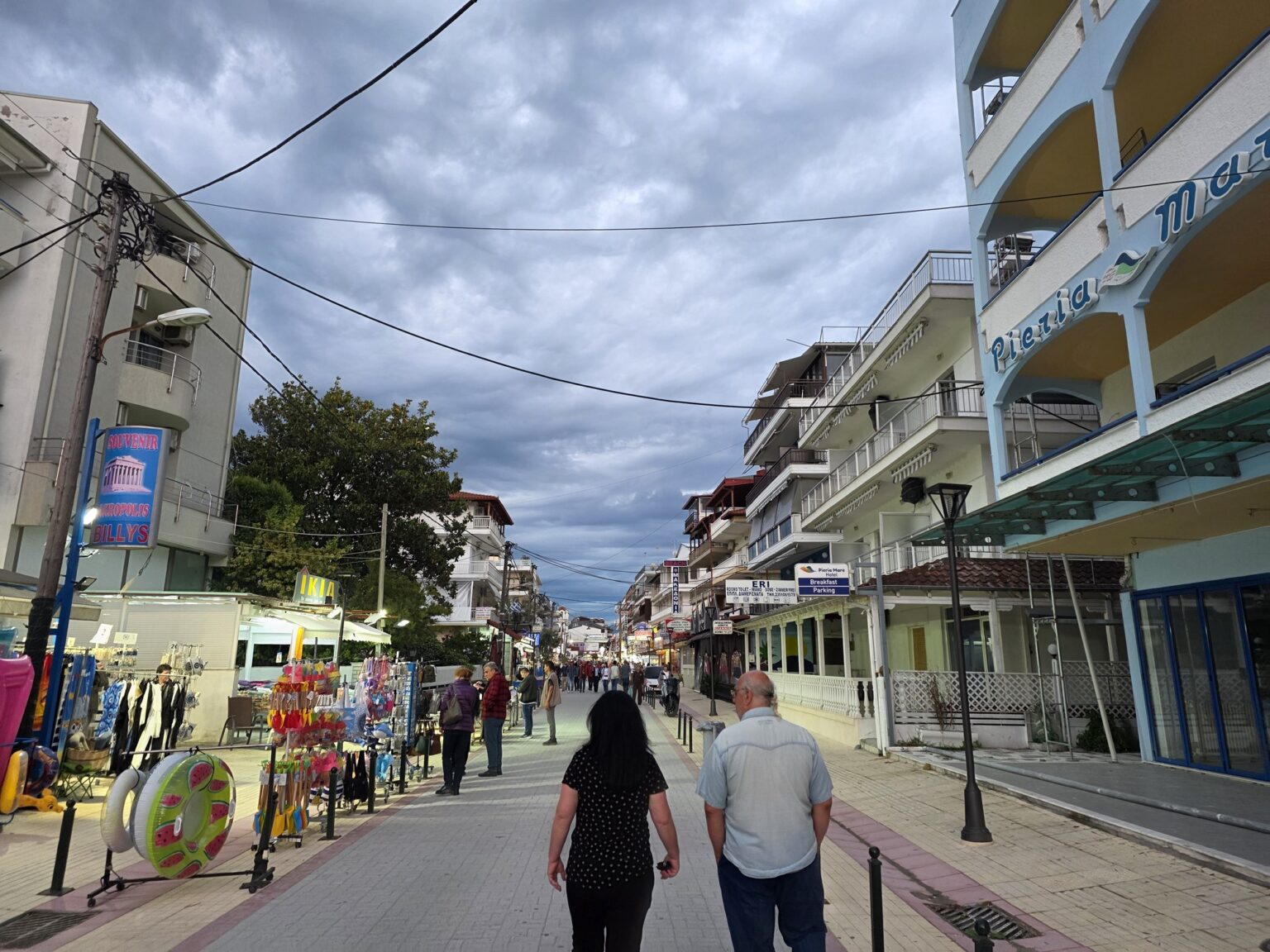 Pedestrians on a busy street with shops