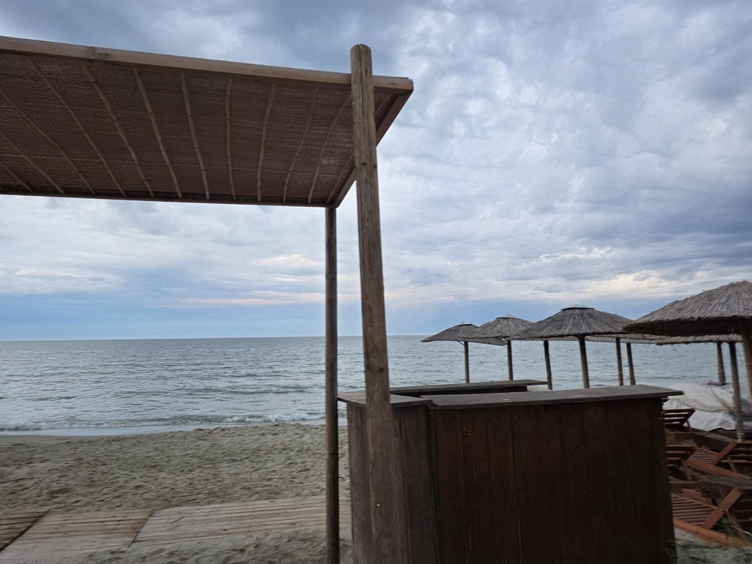 Морски бряг с дървена конструкция под облачно небе